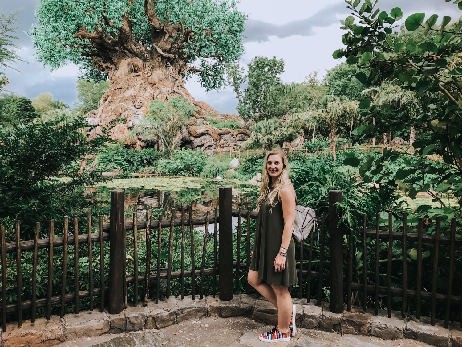 At Animal Kingdom's Tree of Life wearing an olive shift dress, ISKAY colorful handmade shoes, @kutukakiss bracelets, and @violetrayny backpack.