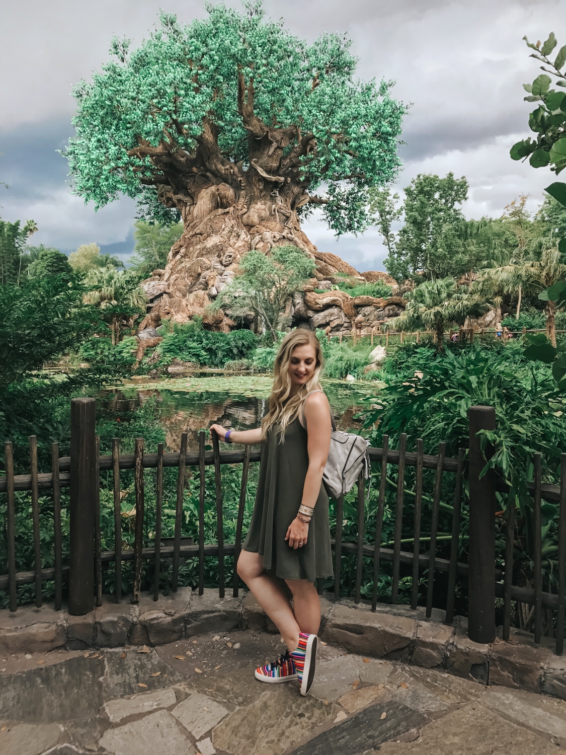 At Animal Kingdom Tree of Life wearing an olive shift dress, ISKAY colorful handmade shoes, @kutukakiss bracelets, and @violetrayny backpack.