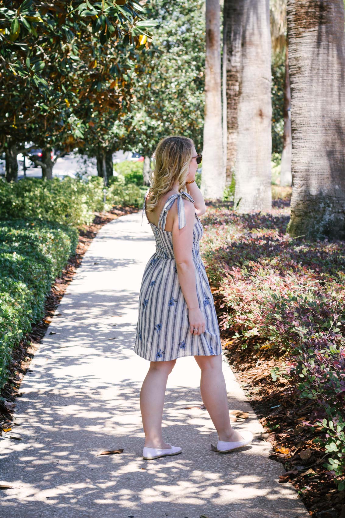 In this summer outfit, lifestyle blogger Allyn Lewis of The Gem styles a playful blue striped dress for a casual look. 