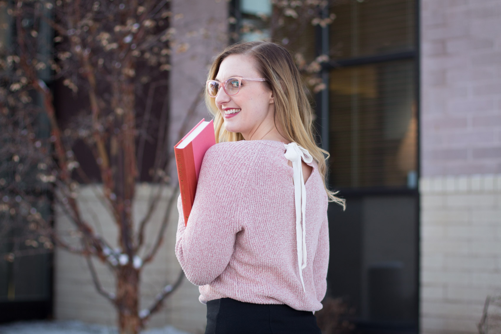 Fashion Blogger Allyn Lewis styles a pink sweater for an everyday, casual outfit complete with pink glasses. 