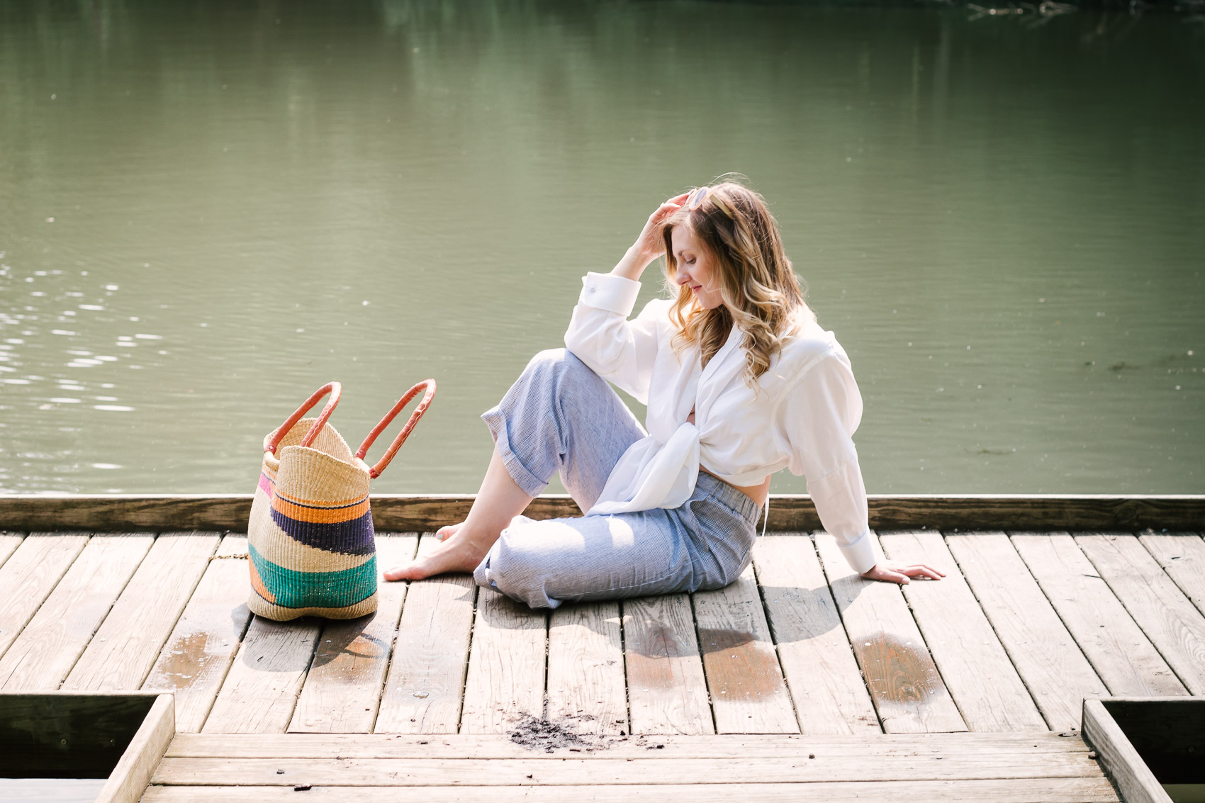 Fashion blogger Allyn Lewis styles an easy summer outfit with linen pants and a woven bag