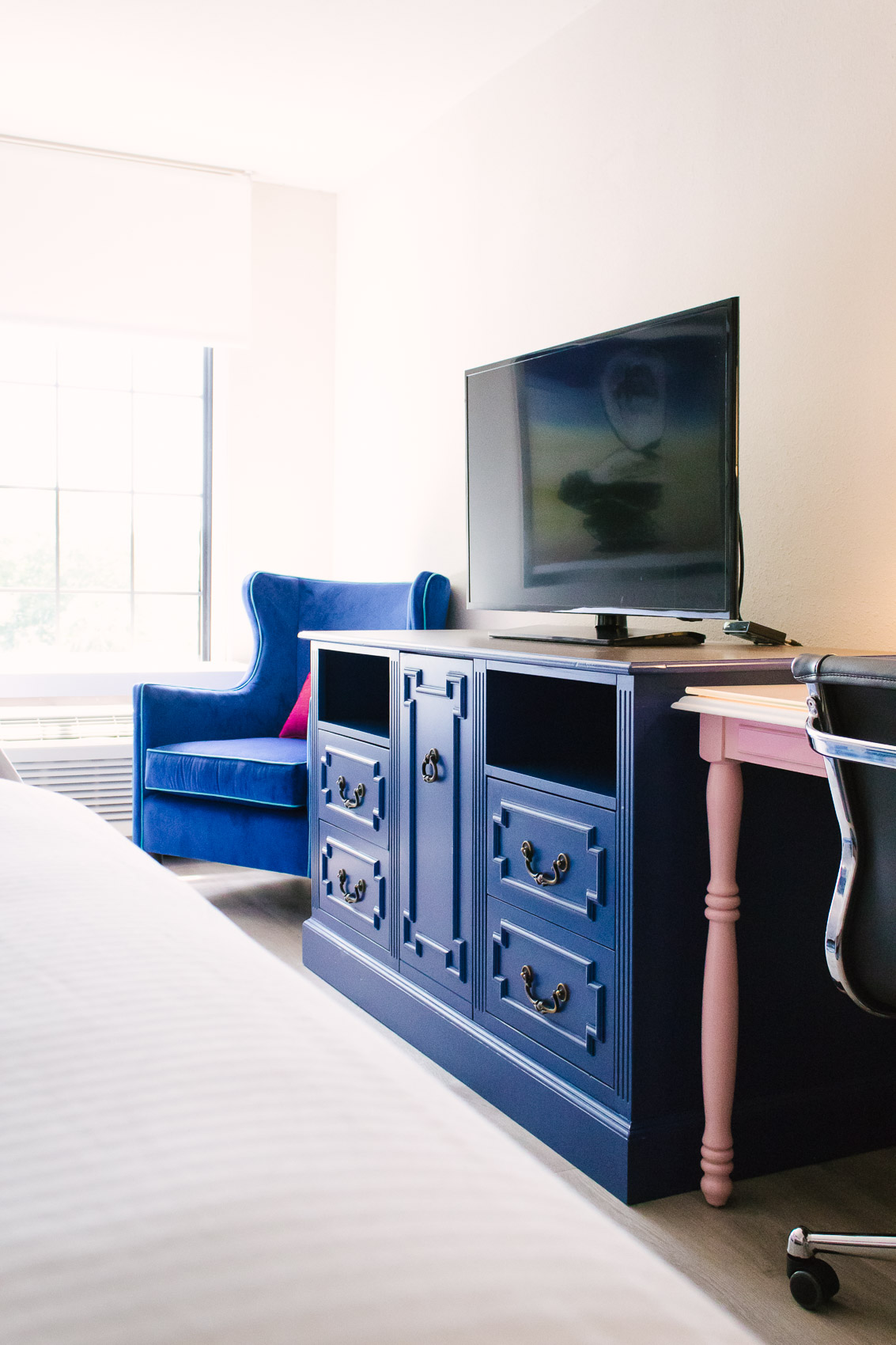 Where to stay in Mount Pleasant, SC: Hotel Indigo - a pet-friendly boutique hotel reflecting the elegant, hip, beachy atmosphere of this sunny oceanfront Charleston suburb. | Travel Blogger | Blue Velvet Chair Decor, Pink Desk, Blue Dresser