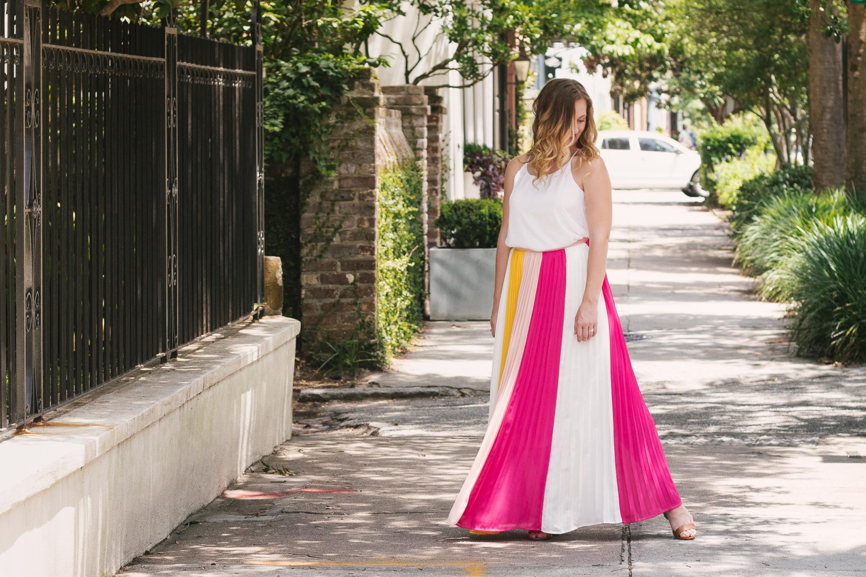 Easy summer outfit: Fashion blogger Allyn Lewis pairs a color blocked pleated skirt with a fresh white cami for an effortless look while exploring Charleston, SC. 