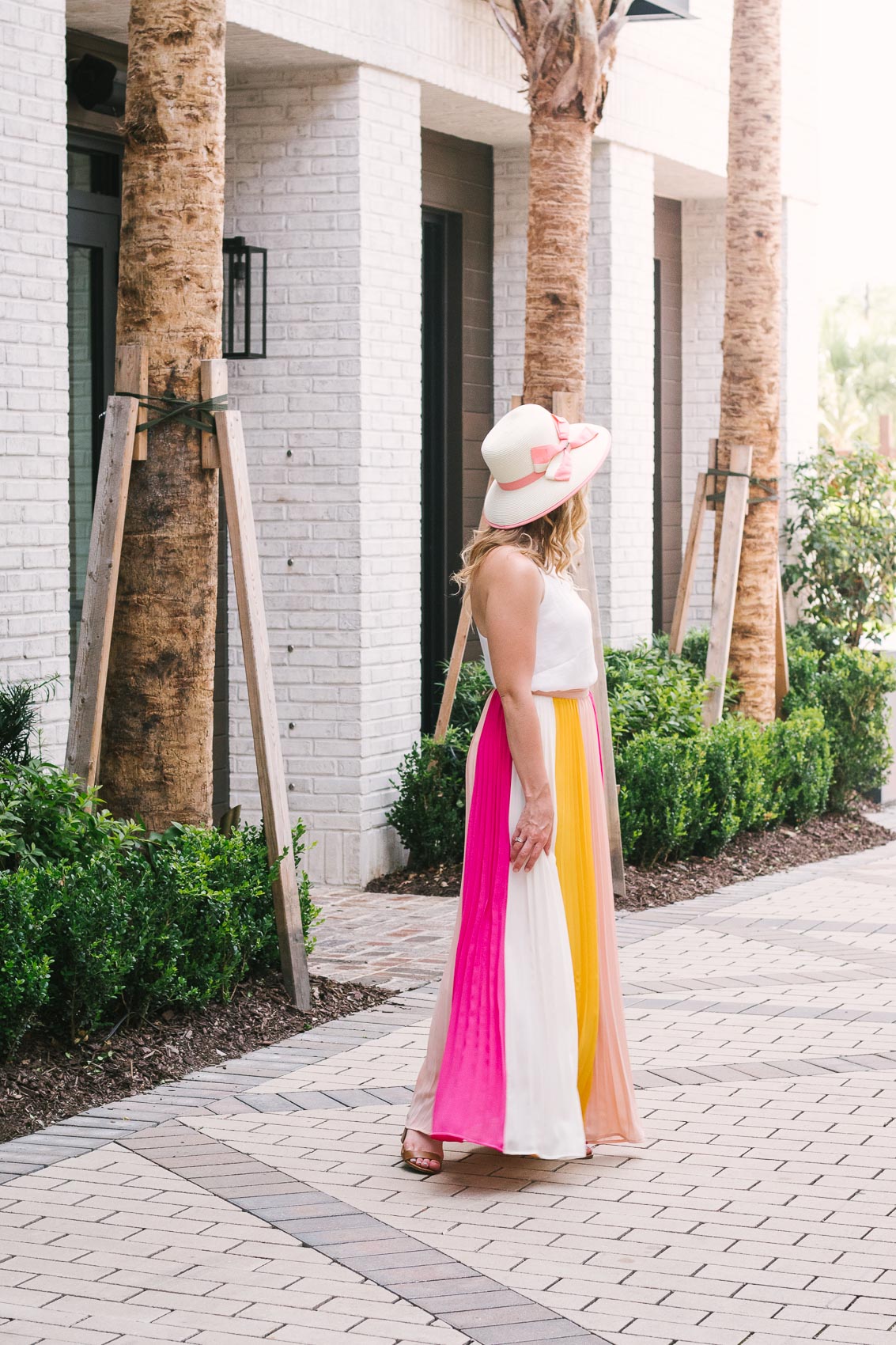 Easy summer outfit: Fashion blogger Allyn Lewis pairs a color blocked pleated skirt with a fresh white cami for an effortless look at Hotel Bella Grace while exploring Charleston, SC.