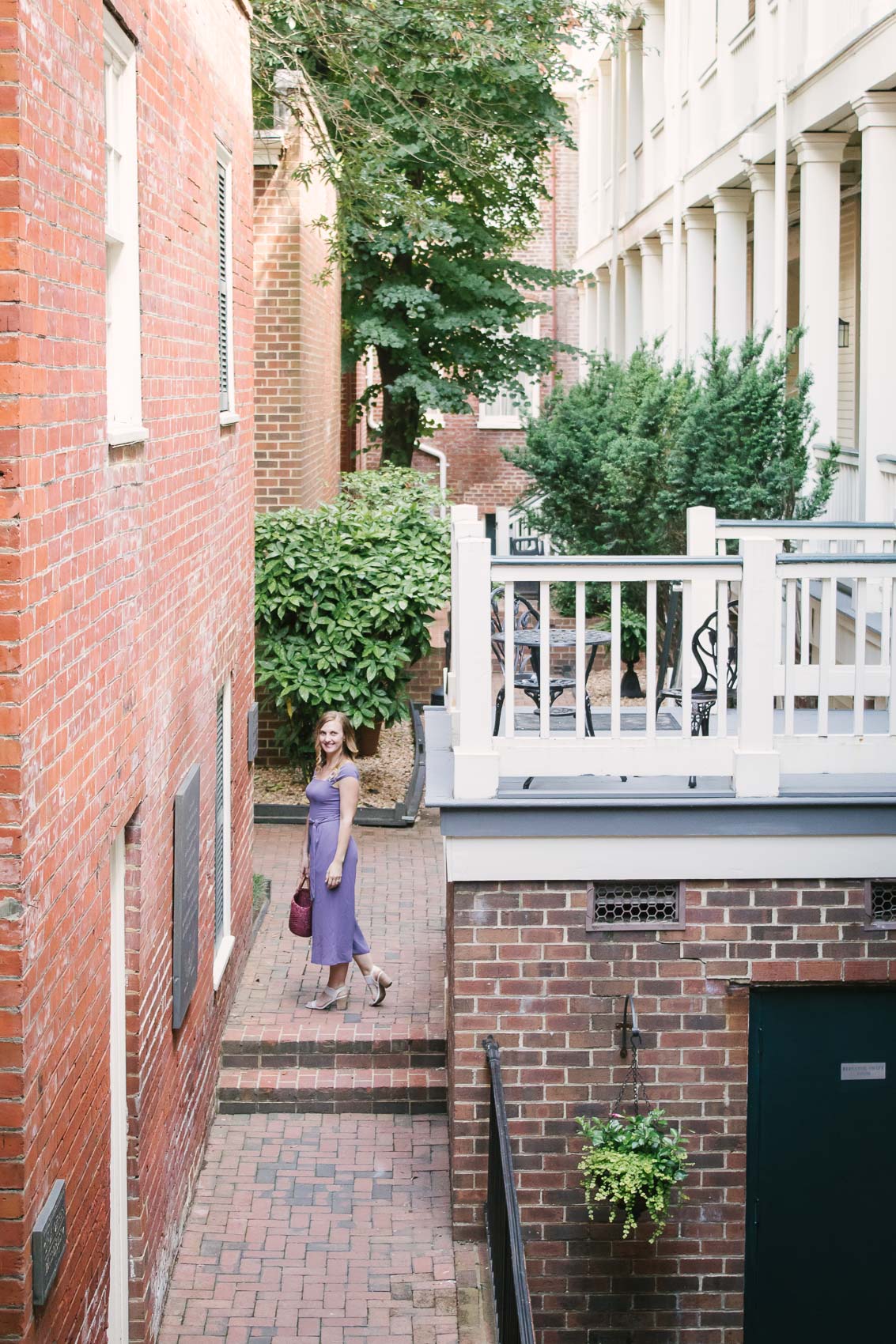 Fashion blogger Allyn Lewis styles the Gal Meets Gal Veronica purple crepe jumpsuit for a casual Summer outfit on a road trip to Linden Row Inn - A historic boutique hotel in Richmond, Virginia