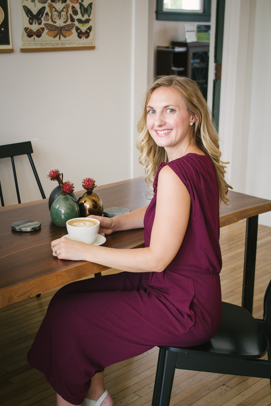 Allyn Lewis of The Gem styles a surplice oxblood casual jumpsuit as a classy summer to fall transitional outfit for a coffee date at Reginald's Coffee in Pittsburgh, PA. 