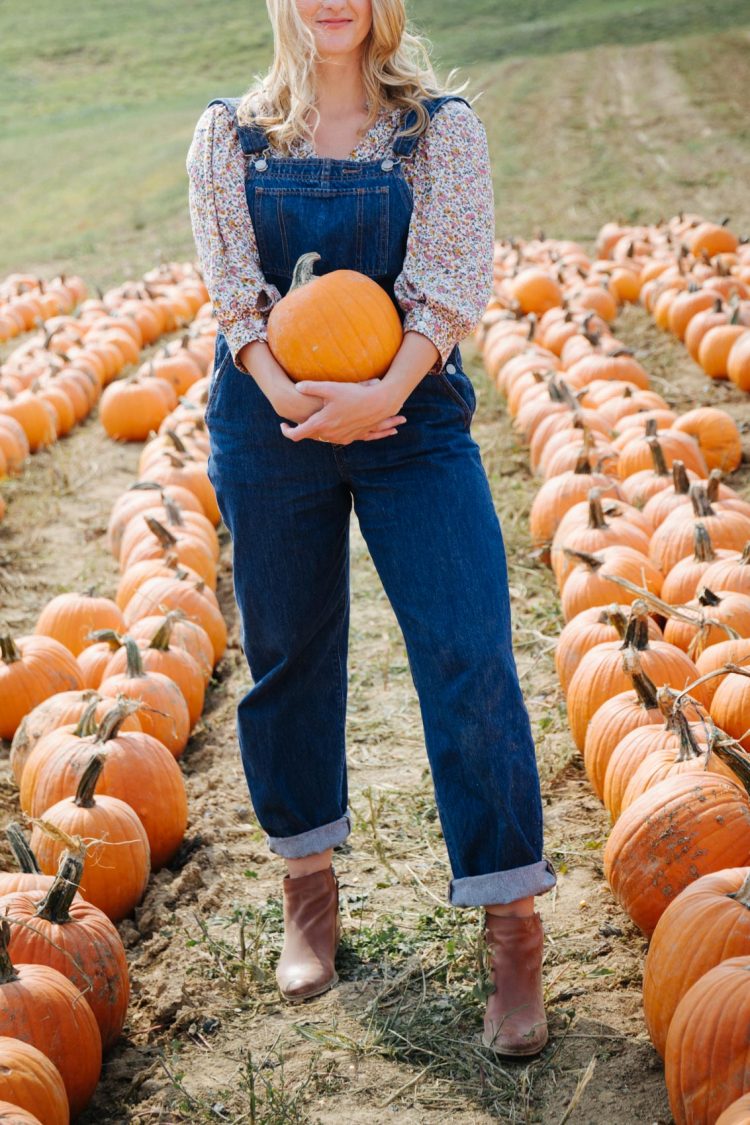 cute fall outfit with floral print puff sleeve blouse and Levi's baggy overalls at the Pumpkin Patch