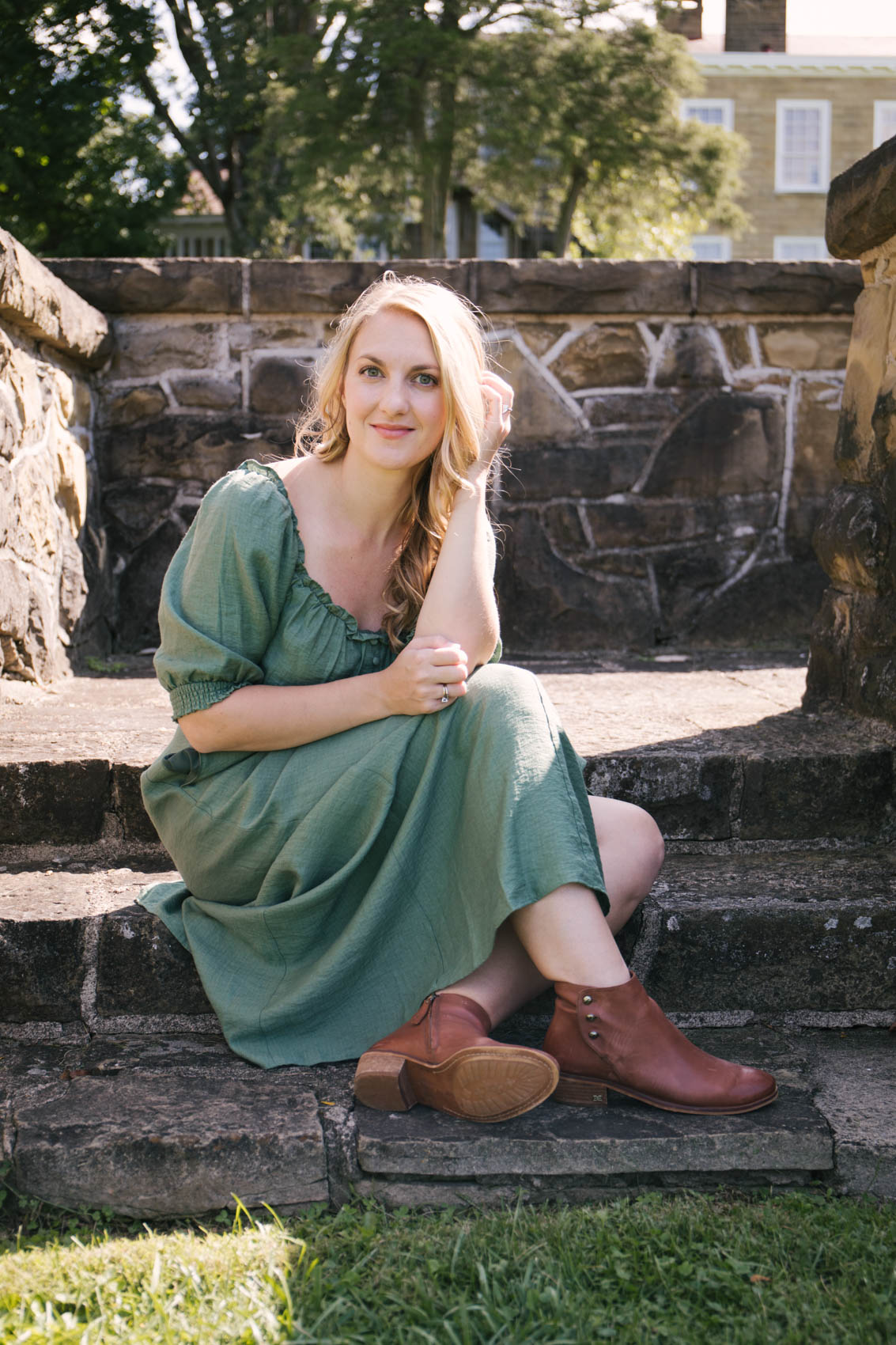 Allyn Lewis styles an easy fall outfit with a flowy green maxi dress and brown ankle booties