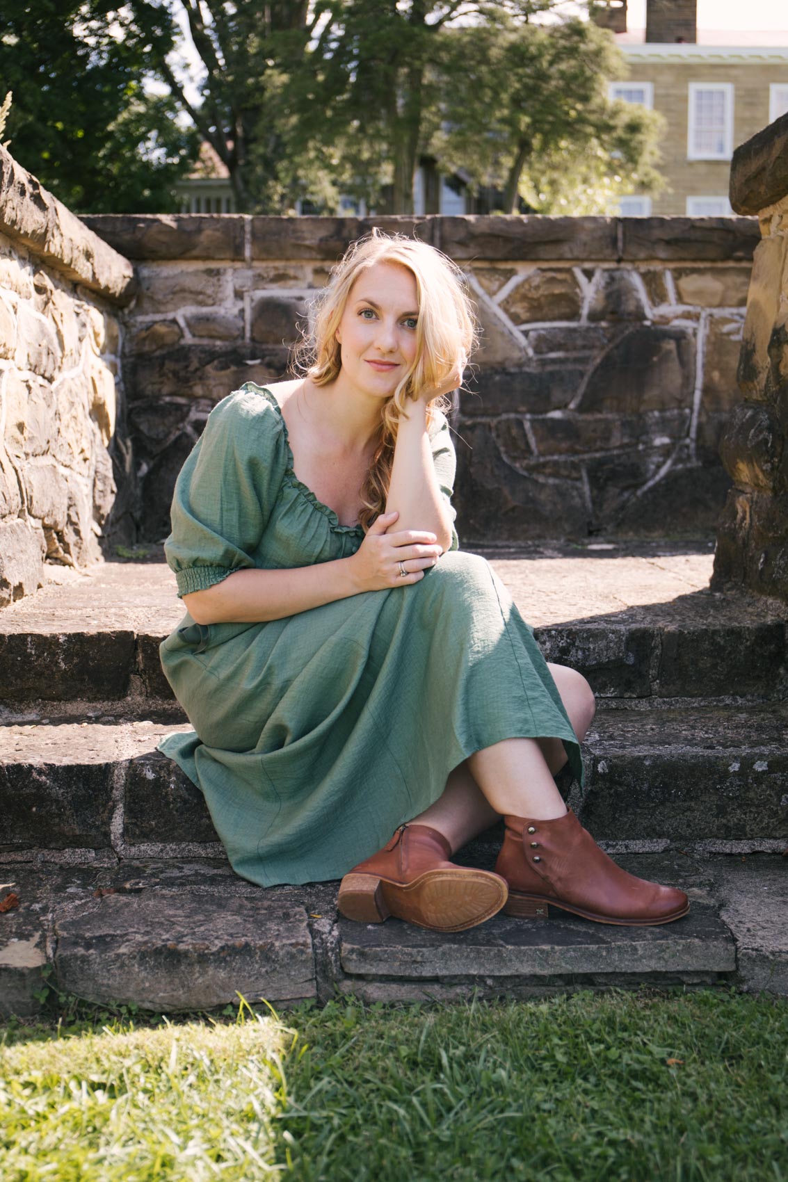 Allyn Lewis in the green puff sleeve Gal Meets Glam Joanna dress and brown ankle booties from Sam Edelman. 