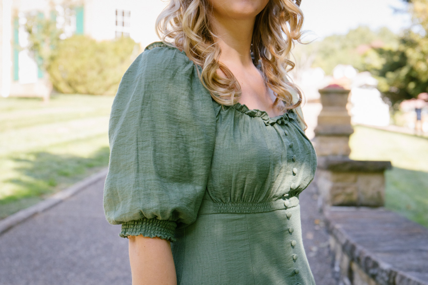 Allyn Lewis styles an elegant outfit with a green puff sleeve dress and brown ankle booties 