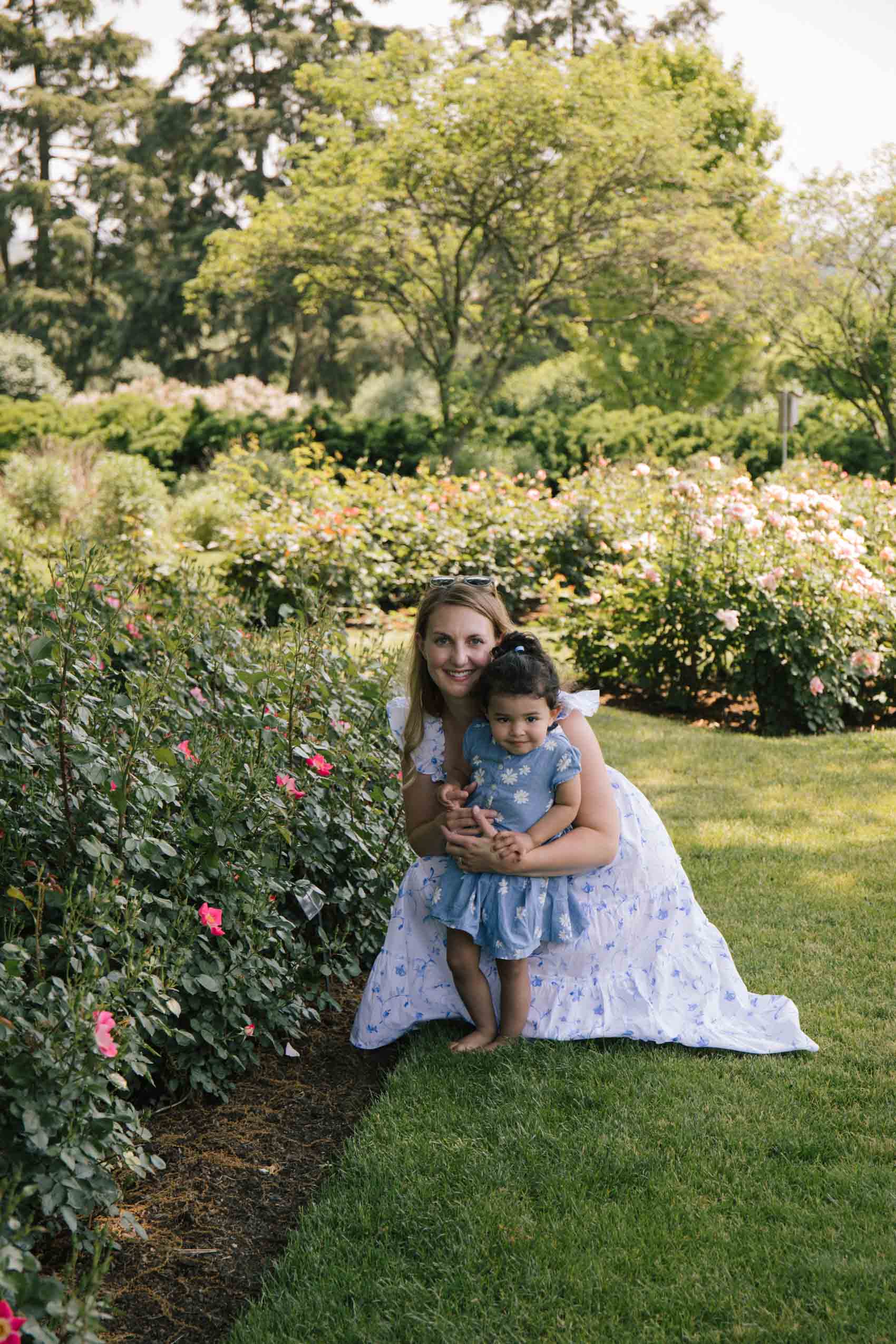 Blogger Allyn Lewis wears a white and blue botanical Hill House Nap Dress at the Hershey Gardens with her toddler niece. 