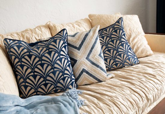 blue and white affordable throw pillows on an off white sofa with a blue blanket on the side