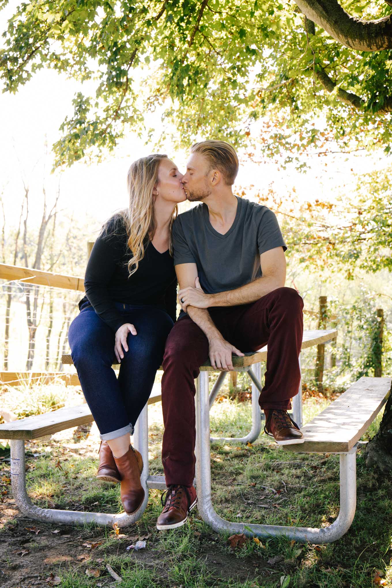 A couple kissing at a local farm wearing casual denim outfits. 
