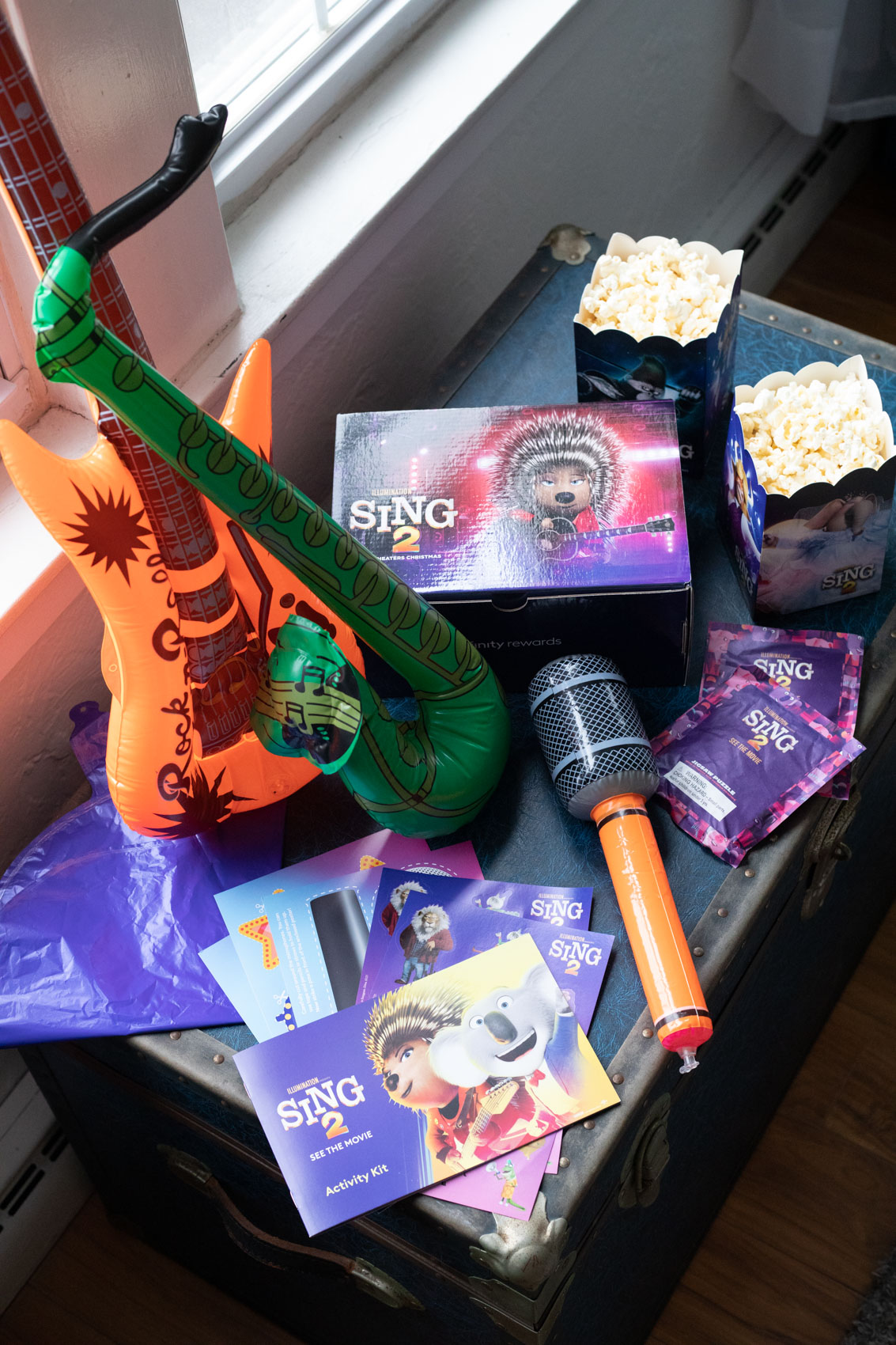 Activity sheets, blow up instruments, popcorn, and puzzles from inside the Sing 2 Movie Night Kit from Xfinity