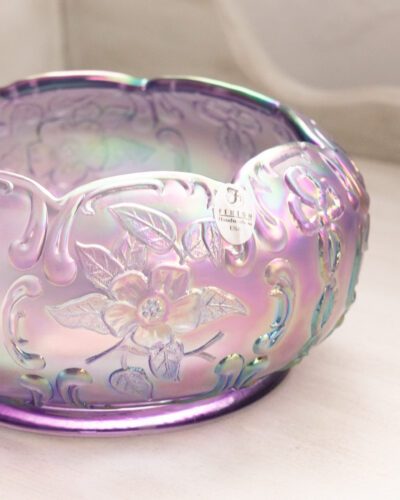 This exquisite Fenton purple floral bowl showcases Fenton's renowned craftsmanship with its mesmerizing iridescent finish and delicate floral patterns, bringing a touch of elegance to any space.