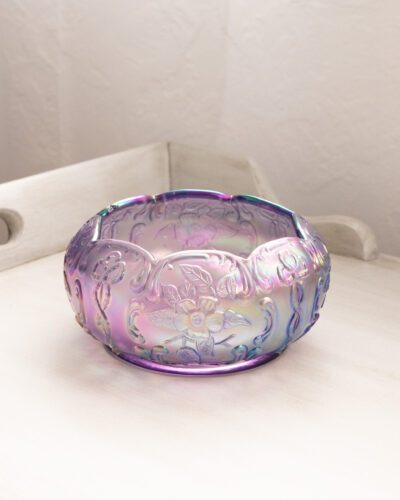 This exquisite Fenton purple floral bowl showcases Fenton's renowned craftsmanship with its mesmerizing iridescent finish and delicate floral patterns, bringing a touch of elegance to any space.