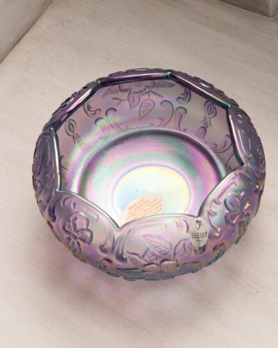 This exquisite Fenton purple floral bowl showcases Fenton's renowned craftsmanship with its mesmerizing iridescent finish and delicate floral patterns, bringing a touch of elegance to any space.